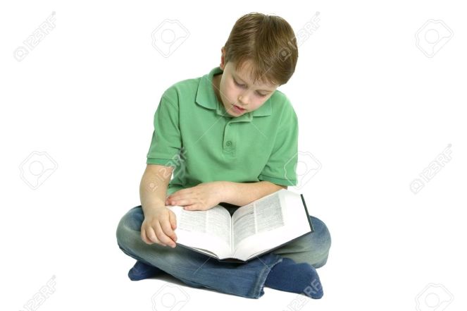 3315655-Boy-of-primary-school-age-sat-crossed-legs-reading-a-reference-book-isolated-on-a-white-background--Stock-Photo.jpg